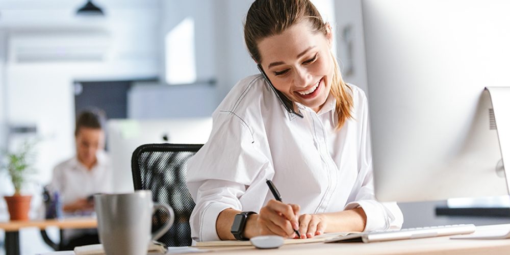 cheerful young businesswoman sitting at her workplace